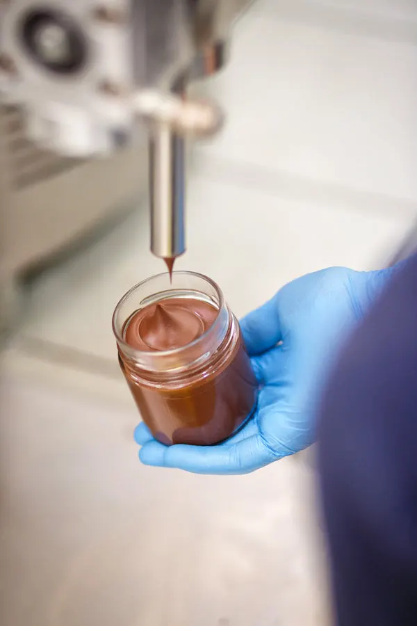 A jar being filled with hazelnut spread in the Noccioro workshop